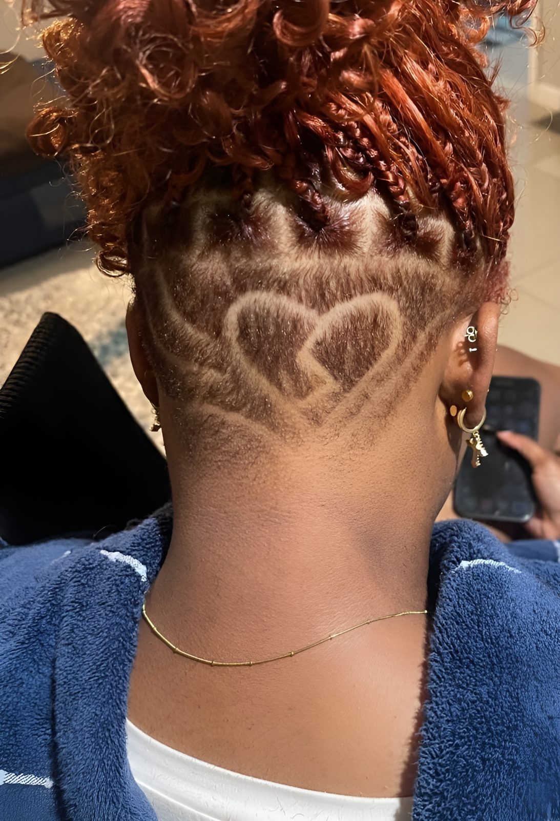 Heart design shaved into the nape under red curls by Rico